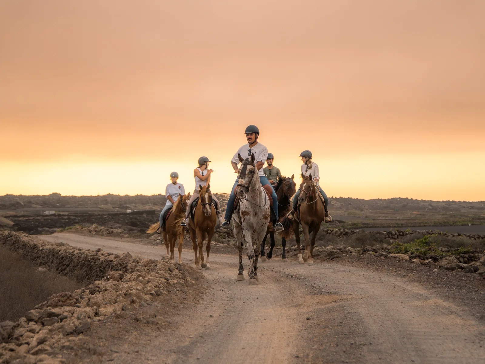 A group on horseback at sunset in Lanzarote