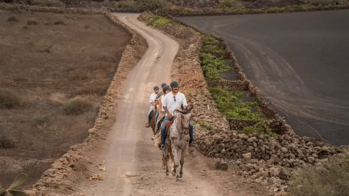 Riders coming up a track between volcanoes