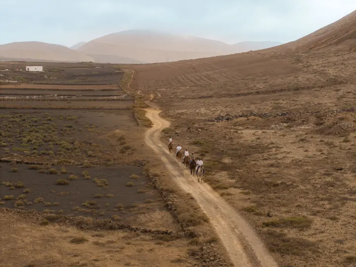 Riders on a ridge looking out over the volcanic craters of central Lanzarote